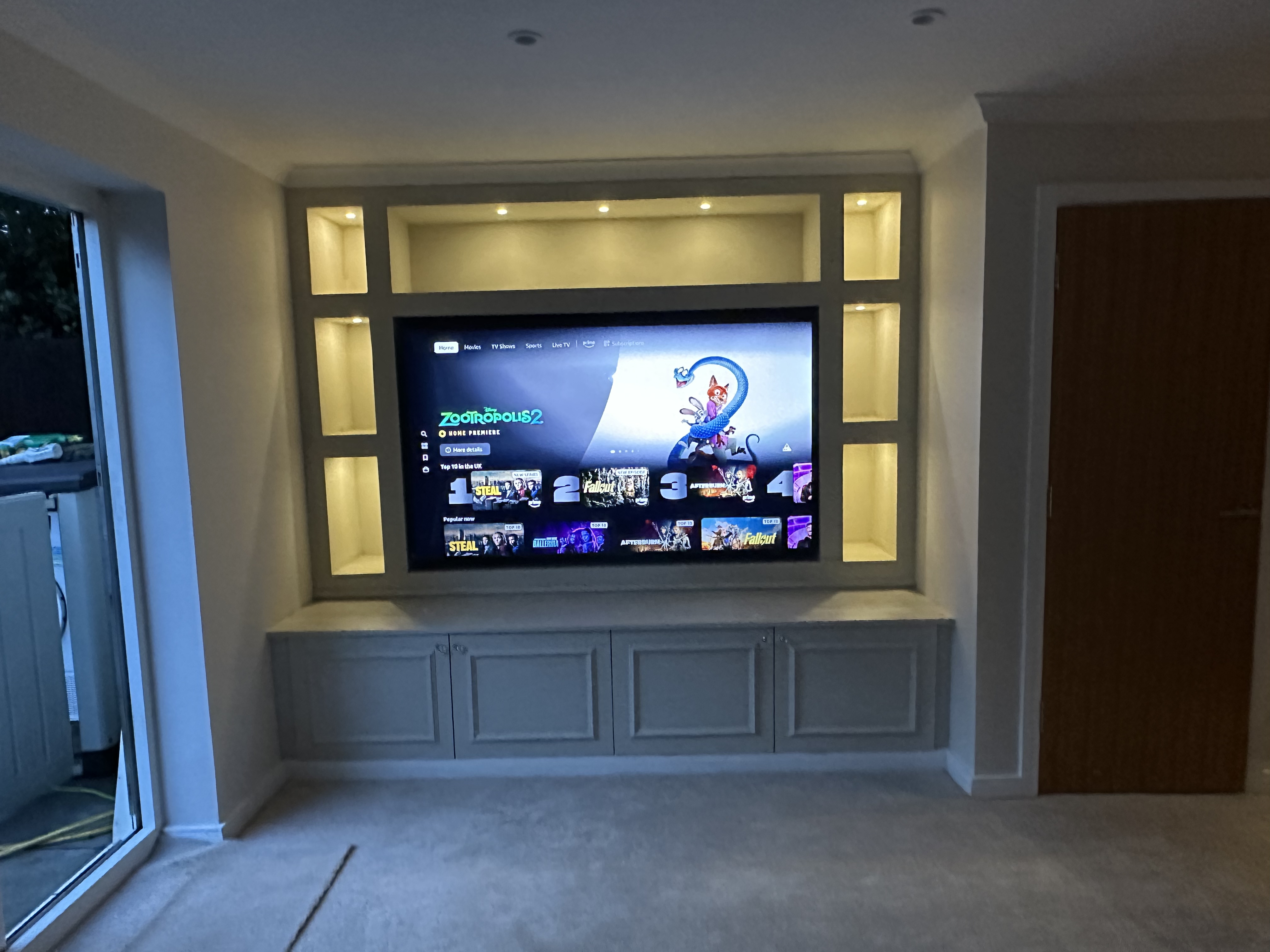 Custom media wall with cabinets and spotlights